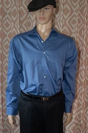 Mannequin wearing a blue button-up shirt, black pants, and a black beret against a patterned curtain background