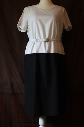Cream short-sleeve belted top paired with a black midi skirt on a mannequin