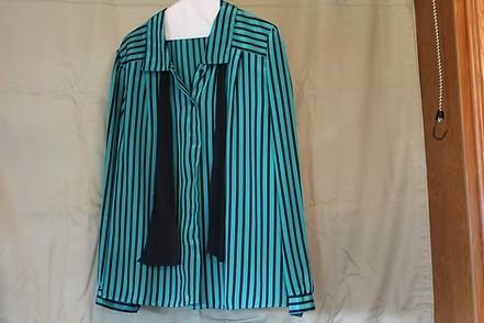 Striped teal and black long-sleeve button-up shirt with black front panels on a mannequin