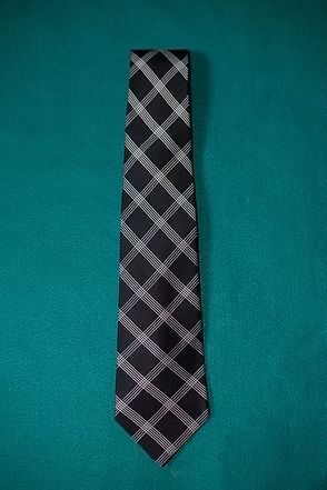 Black and gray plaid necktie on a teal background