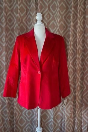 Red blazer jacket displayed on a mannequin against a patterned curtain backdrop