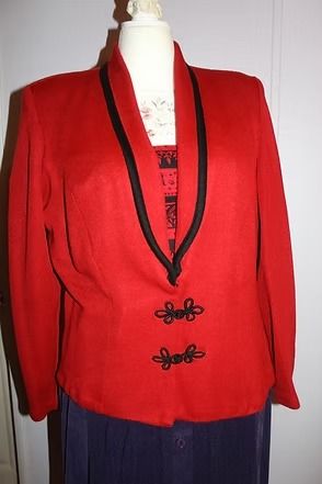 Red blazer with black trim and decorative clasps on a mannequin