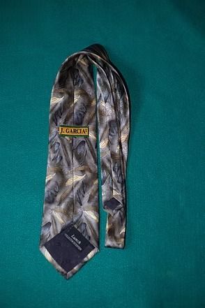 Silver patterned necktie on a teal background
