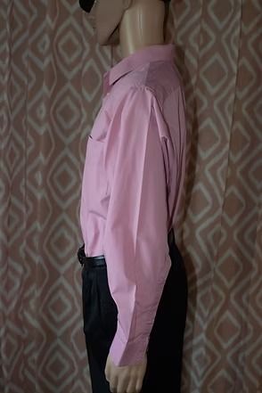 Mannequin wearing a pink button-down shirt, black pants, and a black cap against patterned curtains