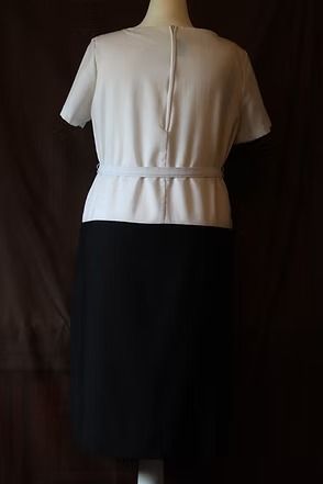 Cream short-sleeve belted top paired with a black midi skirt on a mannequin