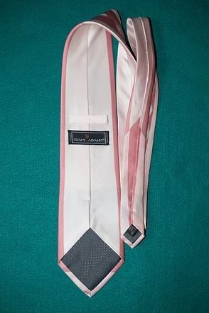 Pink necktie with white diamond pattern on green background