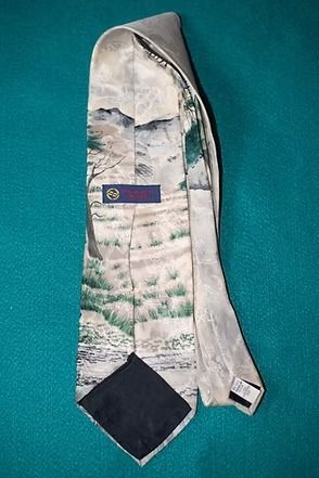 Narrow tie with zebra and tree landscape pattern in muted gray, green, and black