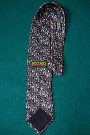 Patterned necktie on teal fabric background