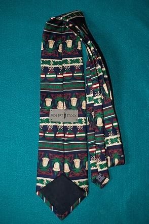Patterned necktie with colorful horizontal stripes and tassel-like motifs on a teal background
