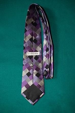 Purple and gray argyle necktie on a teal background