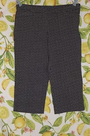 Black-and-white patterned pants laid flat on a lemon-print fabric background
