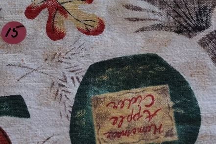 Patterned tablecloth with pumpkins, apples, bread, and fruit on a light background