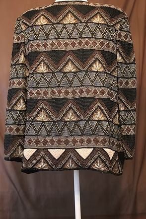 Patterned black-and-gold jacket over a white top on a mannequin