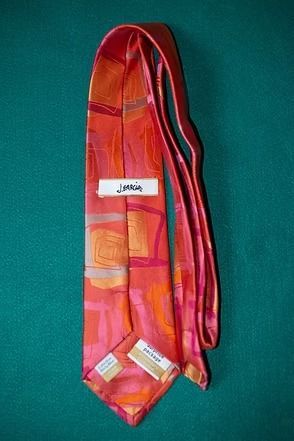 Colorful pink and orange necktie on a teal background