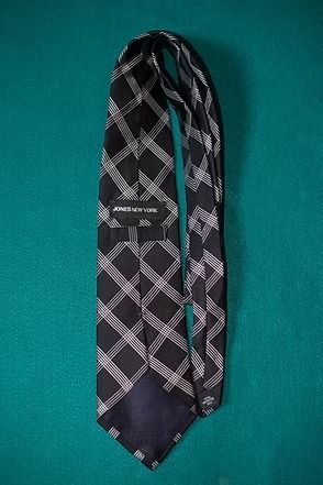 Black and gray plaid necktie on a teal background