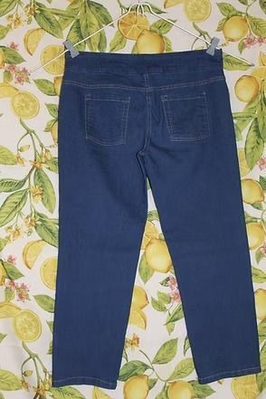 Blue denim jeans laid flat on a patterned floral background.