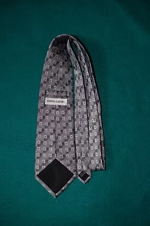 Gray patterned necktie on a green background