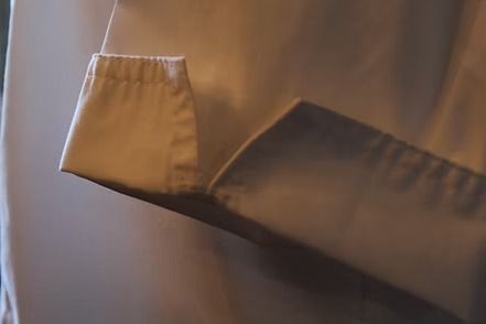 Close-up of a light pink zippered jacket with a vertical seam.
