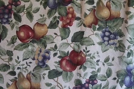 Floral fabric with red apples and pale purple blossoms on a light background