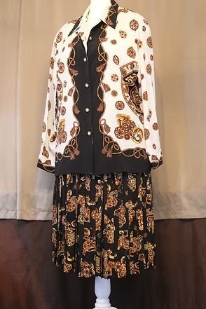 Patterned white jacket over black dress with floral skirt on a mannequin