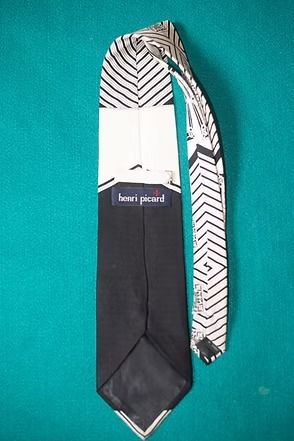 Black-and-white geometric necktie on a teal background