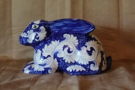 Blue-and-white ceramic rabbit figurine on a wooden surface