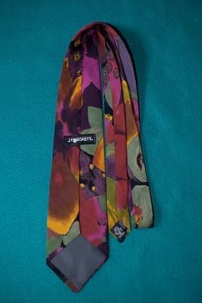 Colorful patterned necktie on a teal background