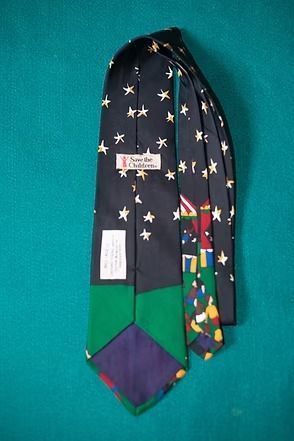 Night-themed necktie with stars, crescent moon, and a colorful carnival scene at the bottom.