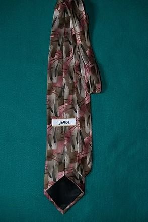 Patterned pink and gray necktie on a teal background