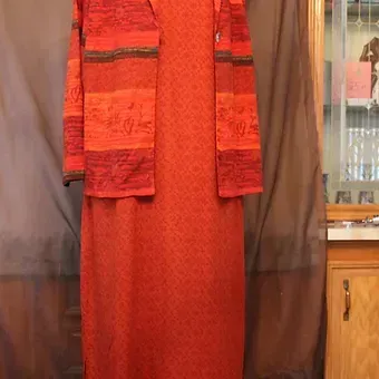 Red long dress with matching jacket displayed indoors on a mannequin.