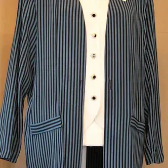 Blue striped blazer over a white buttoned top hanging on a mannequin