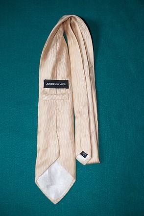 Beige striped necktie on a teal background
