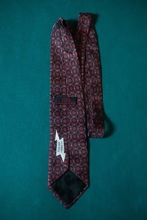 Patterned maroon tie on a teal background