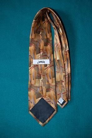 Patterned gold and brown necktie on a teal background