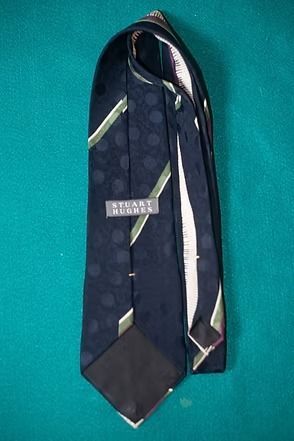 Patterned necktie with purple, white, and green accents on a teal background