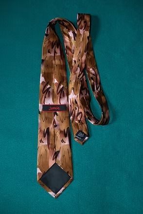Brown patterned necktie on a teal background