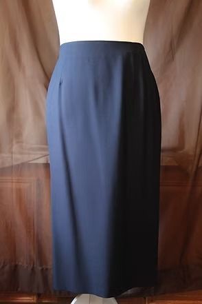 Navy blue long skirt on a mannequin against a brown curtain backdrop
