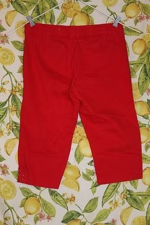 Bright red pants laid flat on a fruit-patterned tablecloth.