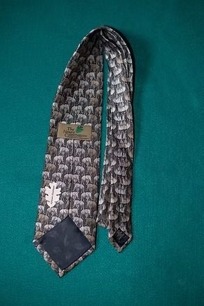 Gray patterned necktie on a teal background.