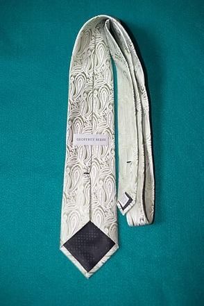 Cream paisley necktie on a teal background