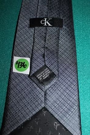Gray patterned necktie on a teal background.