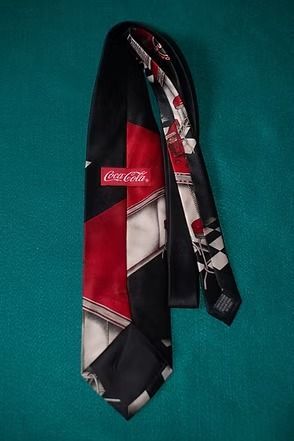 Black and red necktie with a checkered bar scene and red barstools on a teal background