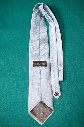 White necktie on a green background