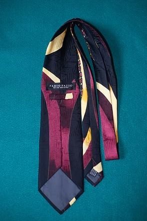 Abstract purple, gold, and cream necktie on a teal background.