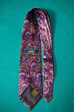 Colorful paisley-patterned necktie on a teal background