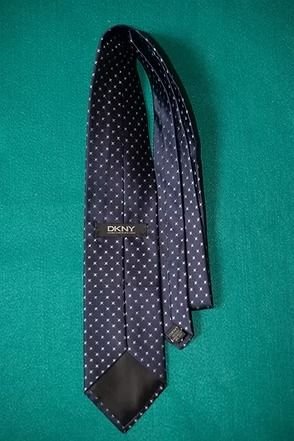Black polka dot necktie on a green background