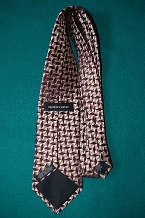Brown patterned necktie on a teal background