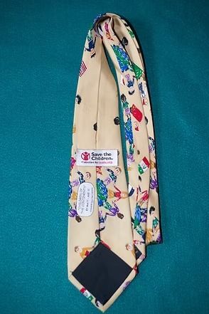 Cream necktie with colorful floral and geometric pattern on a teal background