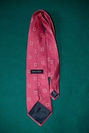 Pink patterned necktie on a green background