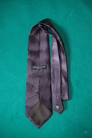 Black patterned necktie on a teal background